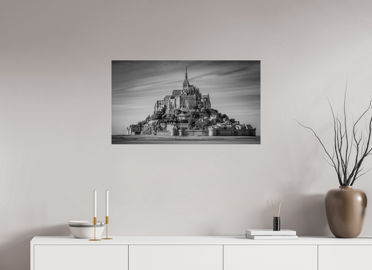 Zwart-witfoto van Mont Saint-Michel in Normandië met middeleeuwse abdij, gotische spitsen en vestingmuren – historische Franse wanddecoratie.
